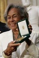 Rachel Robinson is shown accepting the Congressional Medal of Honor for her husband in 2005. (Photo credit: Eric Draper, Wikimedia Commons)